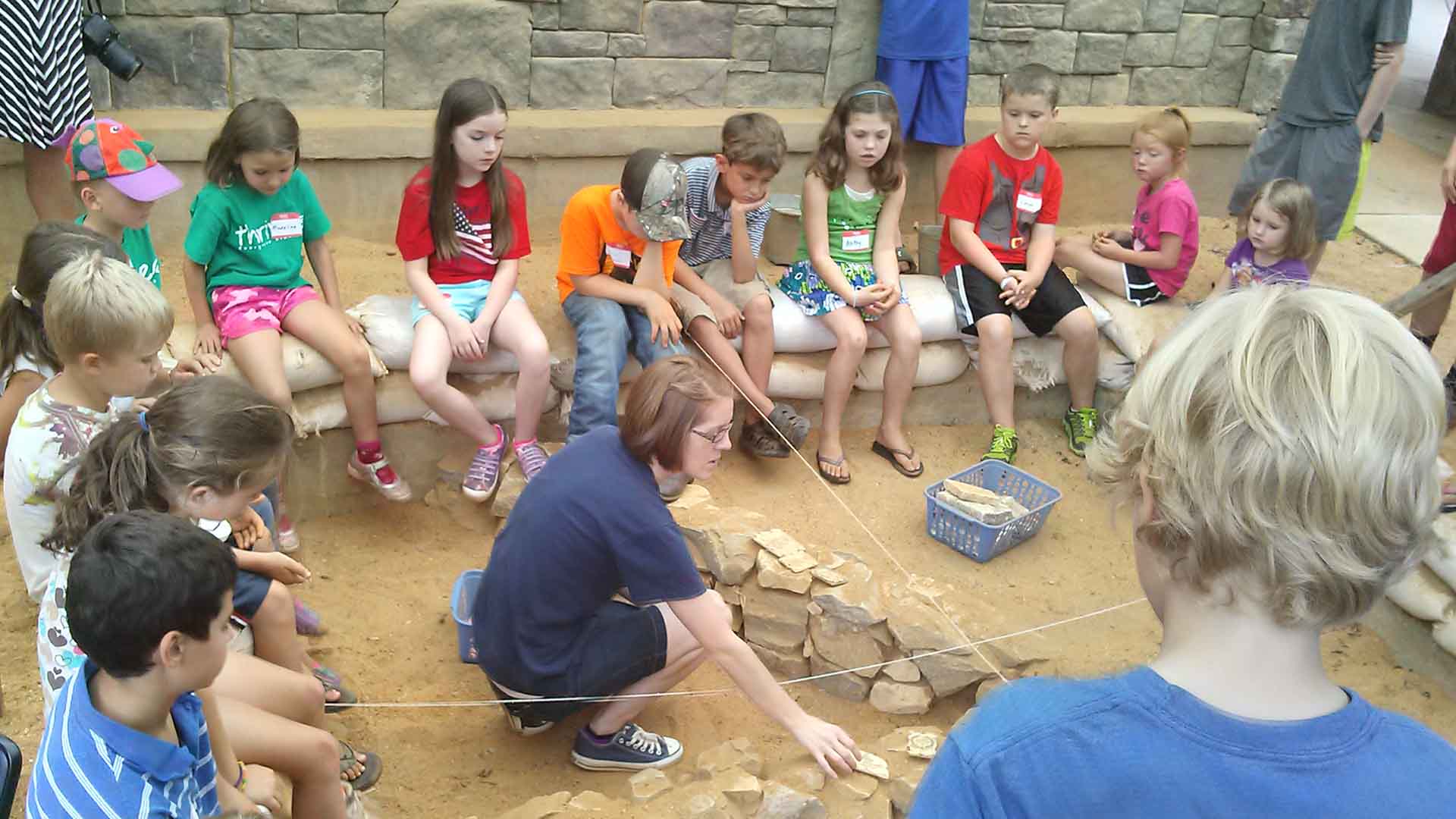 Children enjoying an archaeological presentation at Biblical History Center.