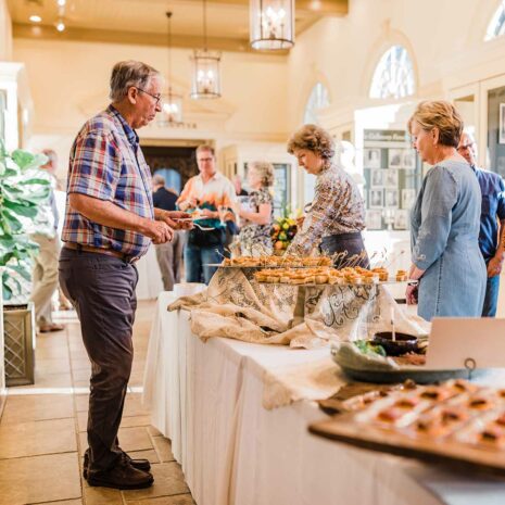 A person serving food at an event hosted in the Hills & Dales Estate visitor center.