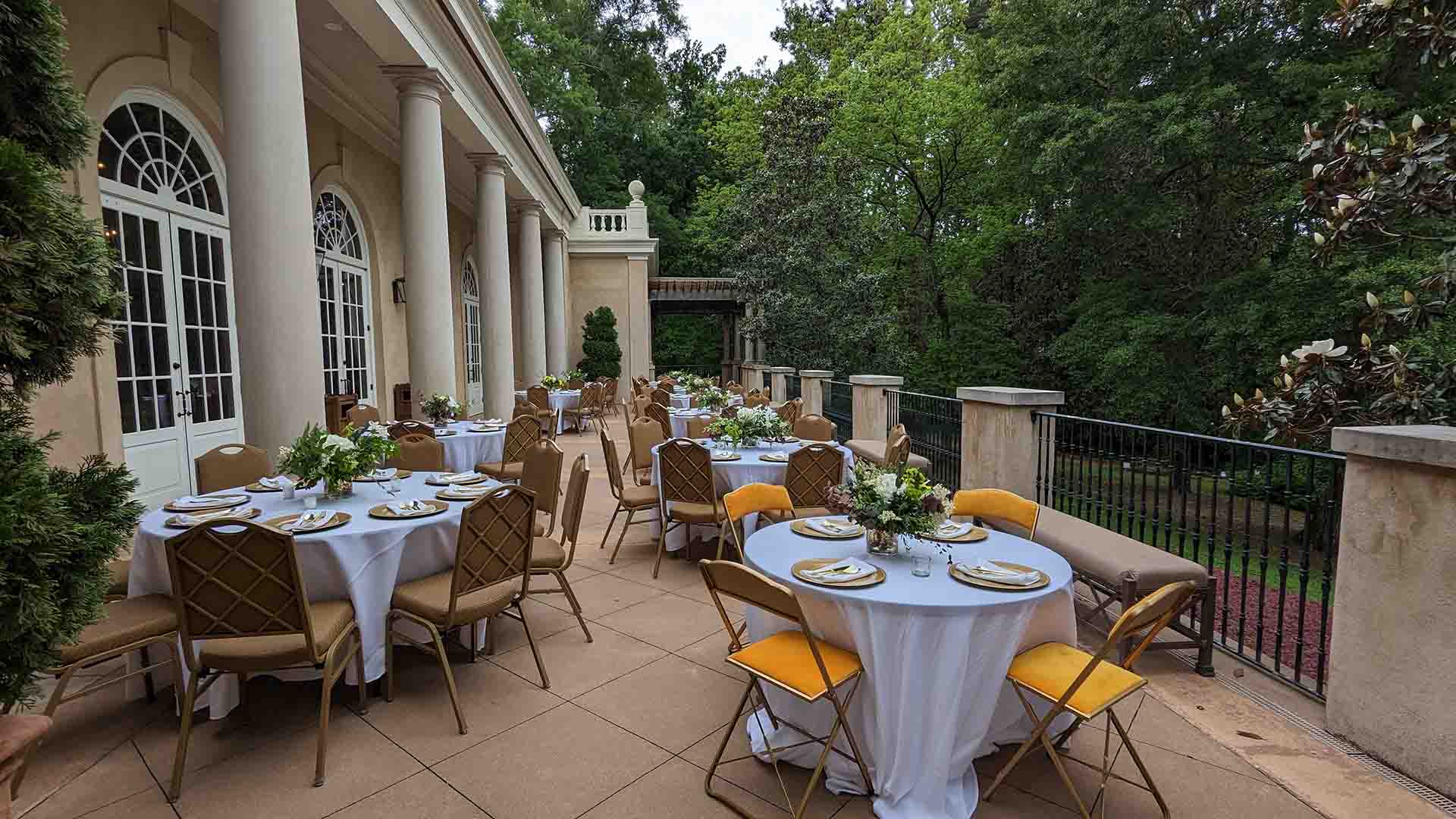 Tables and chairs arranged for an event on the terrace of the Hills & Dales Estate visitor center.