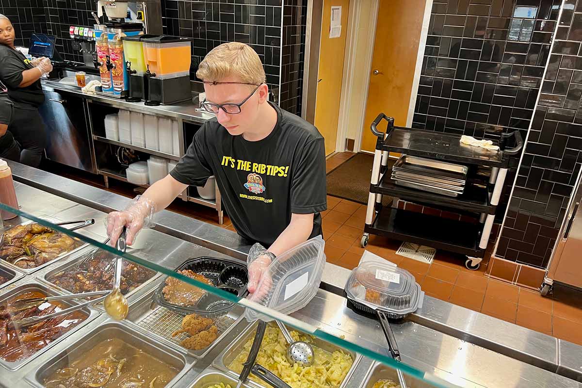 An employee serves food at This Is It! Southern Kitchen & Bar-B-Q in LaGrange, Georgia.