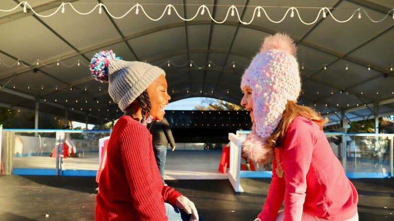 Two girls smiling at Sweetland On Ice - skating in LaGrange, Georgia